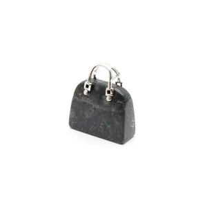 Detailansicht eines Handtaschen-Anhängers aus Naturstein mit silberfarbenen Metallgriffen.