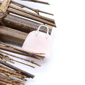 Detaillierte Nahaufnahme eines Handtaschen-Anhängers aus Rosenquarz auf Naturholz