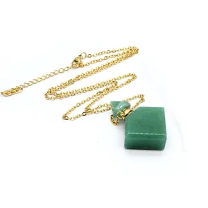 Close-up of a green stone diamond perfume bottle pendant on a gold chain with dropper.