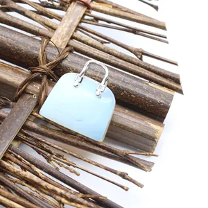 Detailaufnahme eines hellblauen Natursteinanhängers in Form einer Mini-Handtasche