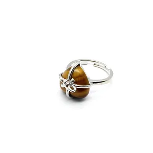 Close-up of heart-shaped tiger's eye stone wrapped in a silver bow ribbon cage