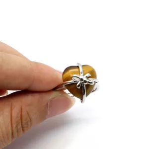 Close-up detail of Tiger's Eye heart ring featuring a decorative silver ribbon bow