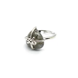 Detail view of heart-shaped natural stone ring with a silver bow ribbon wrap design