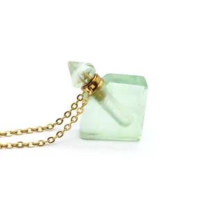Detail view of a light green rhomboid fluorite perfume bottle pendant on a gold chain