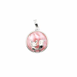 Close-up detail of a silver fox figure on a pink round volcanic stone charm pendant