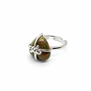Detailed view of adjustable silver ring featuring a heart-shaped natural stone and bow.