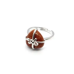Close-up macro view of silver heart ring featuring a glittery brown natural stone inlay