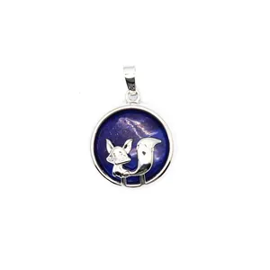 Detail showing a silver fox charm resting on a dark blue starry stone pendant necklace