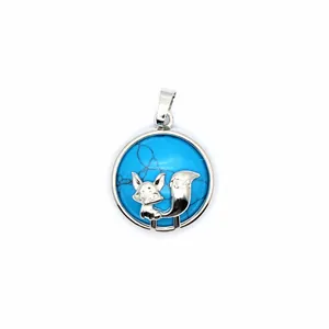 Detailed close-up of a silver fox pendant featuring a vibrant blue stone inlay.