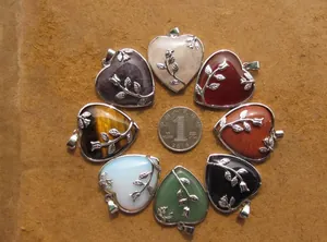 Vue détaillée de divers pendentifs en pierre en forme de cœur avec motifs de roses