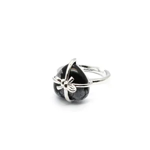 Macro detail view of a heart-shaped snowflake obsidian ring with elegant silver bow