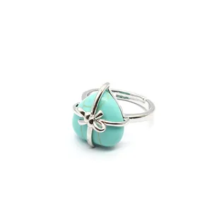 Detailed close-up view of heart-shaped turquoise natural stone ring with silver bow detail.