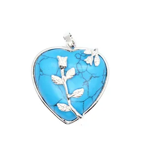 Vue rapprochée d'un pendentif en turquoise en forme de cœur avec rose en argent