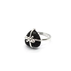 Macro detail view of a heart-shaped black lava stone ring with silver bow wire wrapping