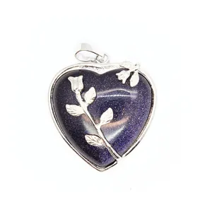 Gros plan d'un pendentif cœur en pierre de soleil bleue avec rose argentée ciselée
