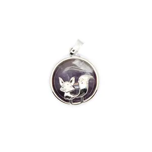 Close-up of a silver fox pendant with a purple stone background on a white surface