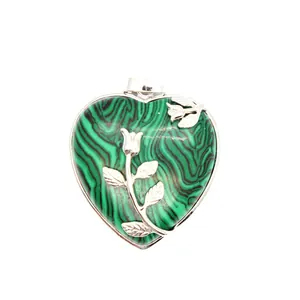 Gros plan détaillé d'un pendentif cœur en malachite avec motif de rose argentée