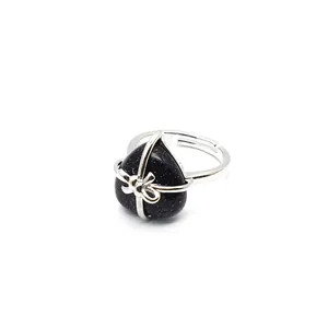 Detailed view of an adjustable heart-shaped blue sandstone ring with a silver bow design