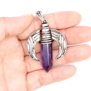 Close-up of vintage dragon wing pendant holding a purple hexagonal crystal point