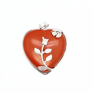 Vue détaillée d'un pendentif en jaspe rouge en forme de cœur avec rose argentée ciselée