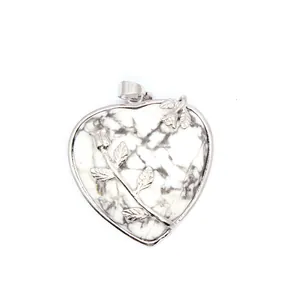 Vue détaillée du pendentif cœur en howlite avec motif de branche de rose argentée