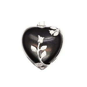 Vue détaillée d'un élégant pendentif en cristal de cœur noir avec gravure de rose argentée