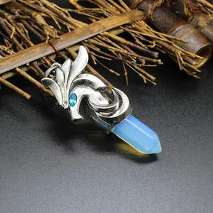 Close-up of vintage silver dragon pendant with light blue hexagonal crystal prism