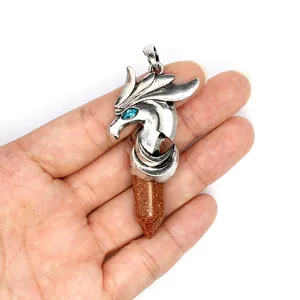 Detailed macro shot of a dragon head pendant with a brown goldstone hexagonal crystal point