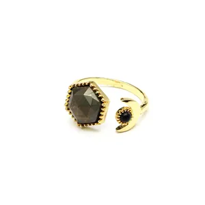 Detailed macro view of gold open ring featuring a faceted hexagon stone and crescent moon
