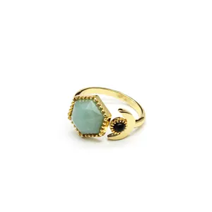 Close-up detail of gold-plated adjustable ring with hexagonal green stone and moon