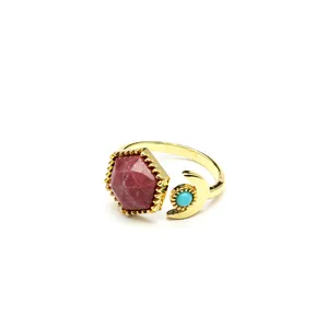 Detailed view of gold open ring with hexagonal red stone and crescent moon
