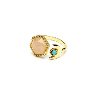 Detailed macro view of a gold open ring featuring a hexagonal peach crystal and turquoise moon