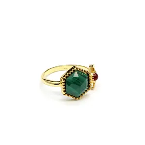 Detail of hexagonal green stone ring with gold band and red side accent