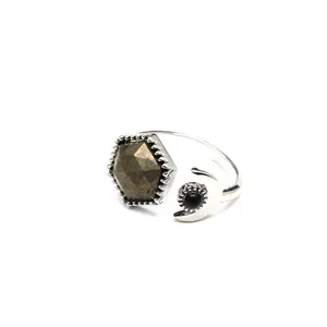 Close-up detail of silver open ring featuring hexagonal pyrite and crescent moon