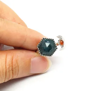 Detail shot of bohemian silver ring featuring hexagonal blue stone and orange gem