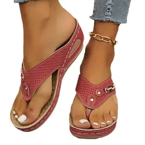 Detail van bordeauxrode wedge teensandalen met geperforeerde bandjes en metaalaccenten