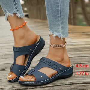 Close-up of navy wedge sandals showing 4.5 cm heel height on wooden path