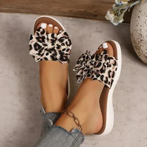 Detailed macro view showing leopard print bow and soft sole of women's beach slides
