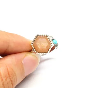 Close-up of hexagonal orange stone and turquoise detail on adjustable silver ring