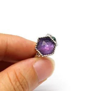Detailed close-up of a vintage hexagonal purple crystal ring featuring a green stone accent