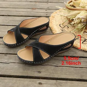 Detailansicht der 5,5 cm Keilabsatzhöhe bei schwarzen Sandalen mit Kreuzriemen.