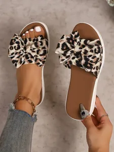 Close-up of leopard print bow-knot flat sandals with soft brown footbed and white sole