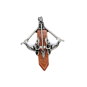 Close-up of vintage crossbow pendant with brown goldstone crystal point
