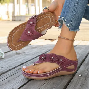 Vista detallada de estas chanclas con cuña moradas con flores y costuras retro