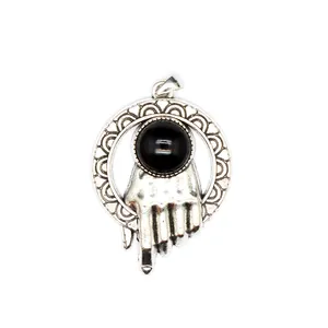 Primo piano di un ciondolo a mano in argento vintage con inserto in pietra nera