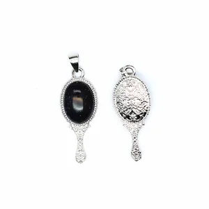 Detail view showing front and back of a vintage magic mirror pendant with blue sandstone.