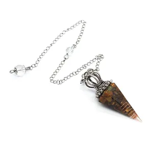 Detailed view of hex-pointed crystal resin pendulum with tiger's eye stone chips.