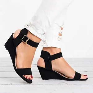 Detailed side view of elegant black wedge sandals featuring a stylish ankle buckle strap