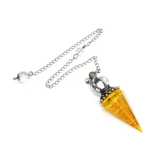 Detailed view of yellow resin crystal pendulum featuring vintage silver crown and chain