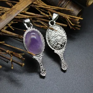 Detailed view of vintage magic mirror pendants with purple amethyst and ornate silver engravings